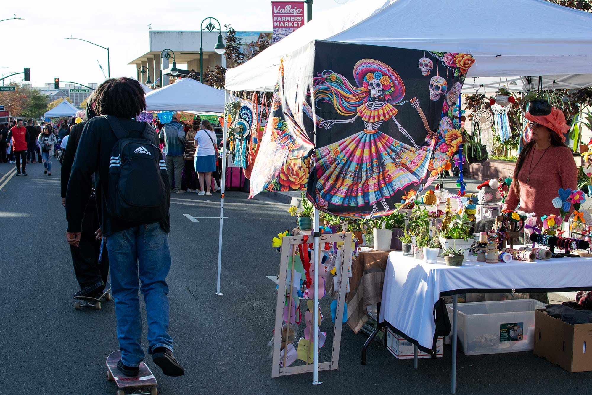 Skateboarders roll into Saturday's Dia de Los Muertos festival.